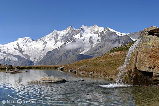 Foto:: Bergsee mit Wasserfall vor Schneebergen (Foto,Fotos,Bilder,Bild,)
